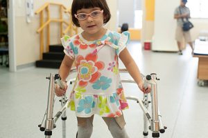 Paciente de andador durante sessões da fisioterapia infantil.