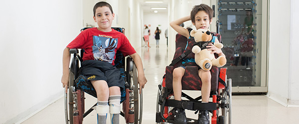 Dois meninos em cadeiras de rodas