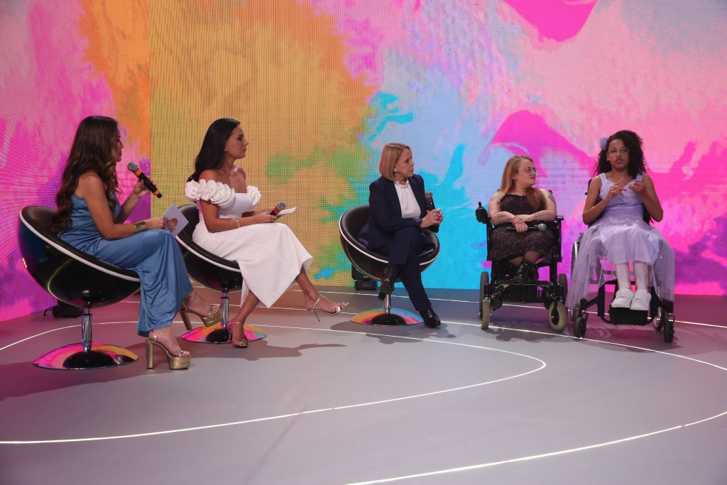 Fernanda Souza, paciente-símbolo, e Thabata Penassi, psicóloga, interagem com artistas no palco do Teleton 2024