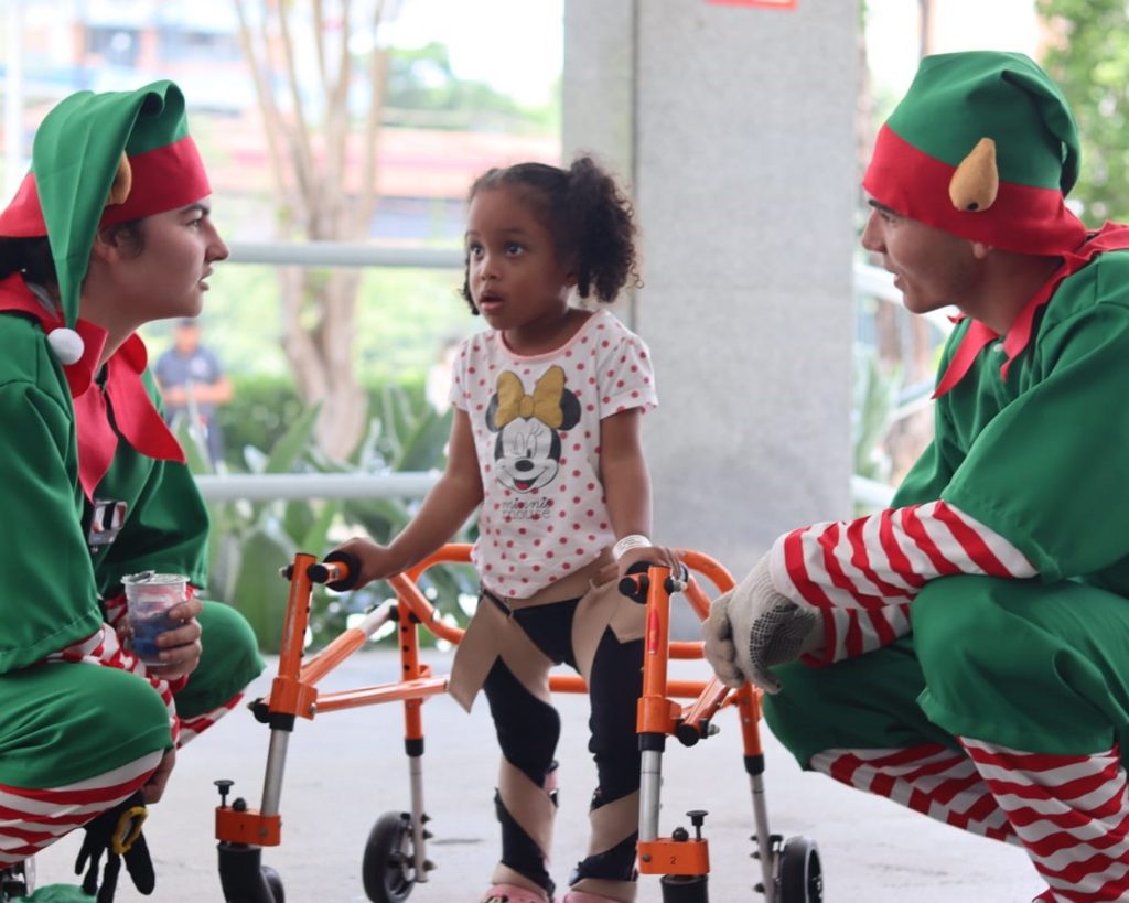 Paciente brinca com duendes em ação de Natal promovida pela Sapore na AACD