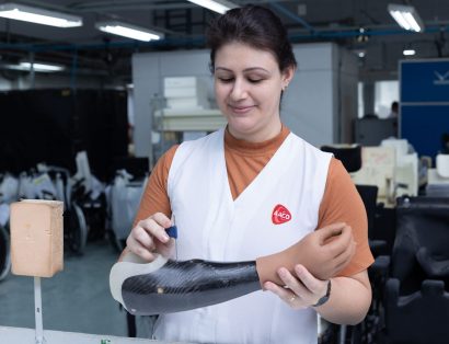 Funcionária da AACD mexendo em uma prótese feita com resina