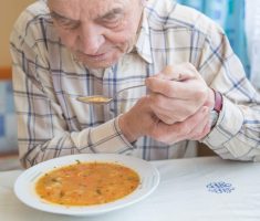 Pessoa com Parkinson se alimentando