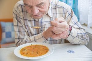 Pessoa com Parkinson se alimentando