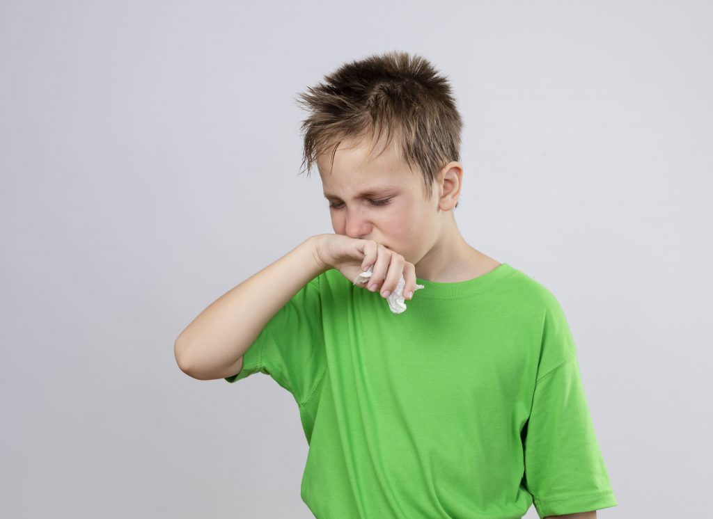 Menino de camisa verde com engasgo