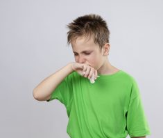 Menino de camisa verde com engasgo
