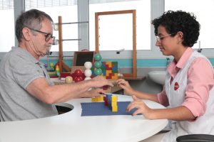 Paciente com sequelas de AVC realiza exercício com blocos na área de Terapia Ocupacional da AACD