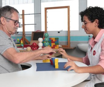 Paciente com sequelas de AVC realiza exercício com blocos na área de Terapia Ocupacional da AACD