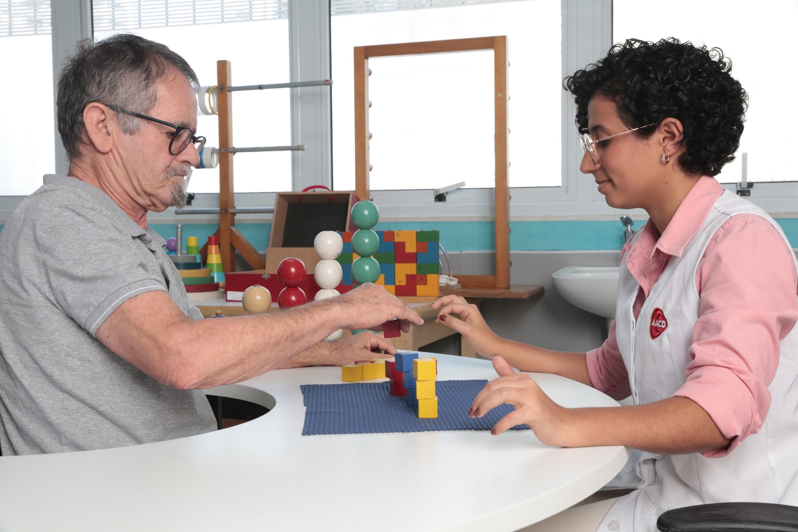 Paciente com sequelas de AVC realiza exercício com blocos na área de Terapia Ocupacional da AACD