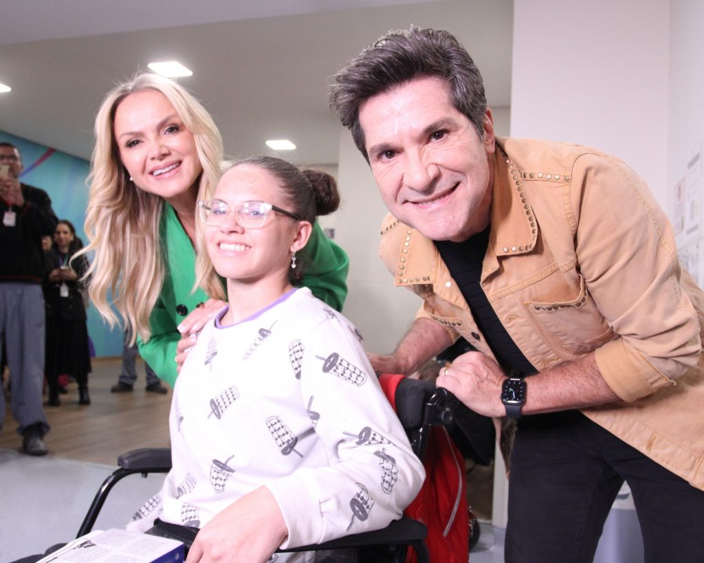 Eliana e Daniel, madrinha e padrinho do Teleton, interagem com paciente da AACD