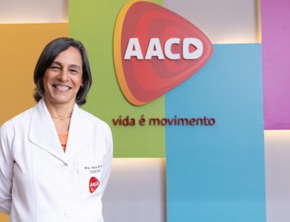 Dra. Alice Rosa Ramos, médica especializada em Fisiatria, atrás de fundo colorido com logo da AACD