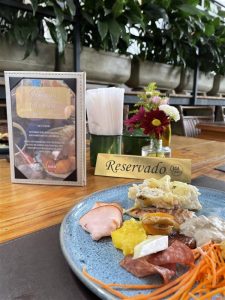 Prato com iguarias em uma mesa de madeira com uma placa dourada escrito "Reservado"