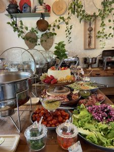 Buffet da Ação Solidária Casa Brasil com variedades de saladas, frutas e comidas.