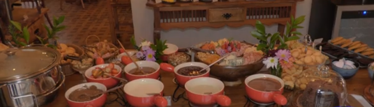 Mesa de madeira com comidas variadas na ação Casa Brasil Gastronomia