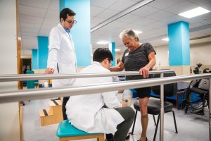 Mulher com prótese na perna sendo atendida na fisioterapia 