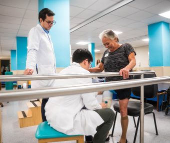 Mulher com prótese na perna sendo atendida na fisioterapia