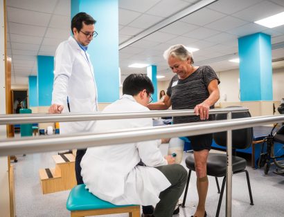 Mulher com prótese na perna sendo atendida na fisioterapia
