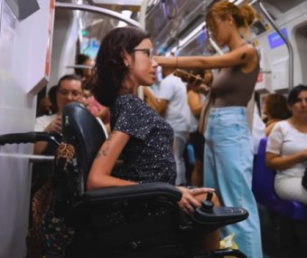 Mulher com deficiência física, que utiliza cadeira de rodas motorizada, no metrô de São Paulo