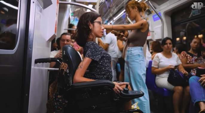 Mulher com deficiência física, que utiliza cadeira de rodas motorizada, no metrô de São Paulo