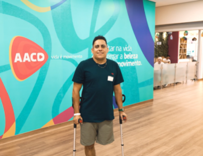 Paciente amputado atrás de fundo institucional da AACD como parte de campanha de conscientização de campanha sobre segurança no trânsito