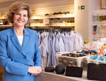 Silvia Paz, superintendente da AACD, no bazar da Instituição ao lado roupas e produtos eletrônicos