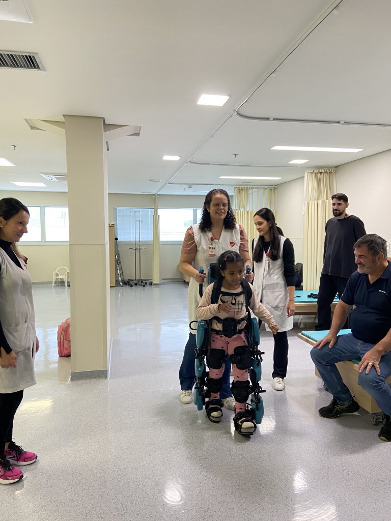 Paciente utiliza o exoesqueleto infantl com auxilio de fisioterapeutas da AACD.