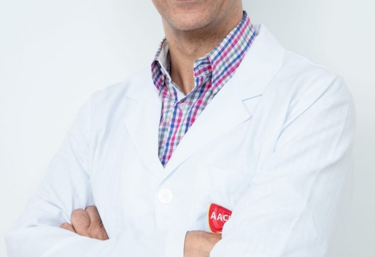 Dr. Marcelo Ares, fisiatra e coordenador médico da AACD, de camisa, jaleco e braços cruzados