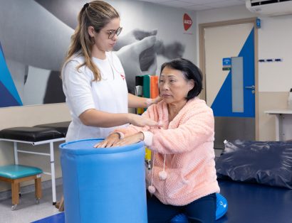 Fisioterapeuta orienta uma paciente idosa durante exercício no Centro de Reabiltação da AACD