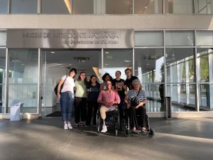 Grupo Psicossocial da AACD posa na entrada do Museu de Arte Contemporânea.