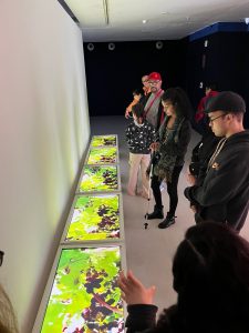 Pacientes da AACD visitam exposição e olham intervenção artistica.