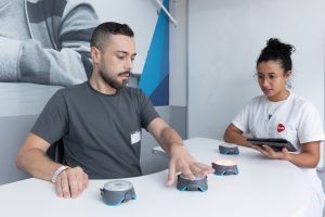 Paciente realiza atividade de resposta a estímulos luminosos com profissional da AACD.