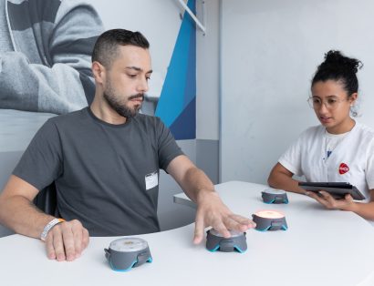 Paciente realiza atividade de resposta a estímulos luminosos com profissional da AACD.
