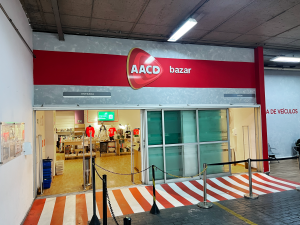 Entrada de bazar da AACD com produtos expostos no interior da loja.