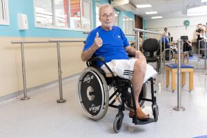 Homem em cadeira de rodas participa de atividade durante atendimento de reabilitação na AACD