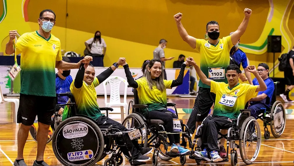 Atletas da bocha paralímpica Maciel Santos, Andreza Oliveira e Iuri Silva comemoram conquista esportiva em quadra.